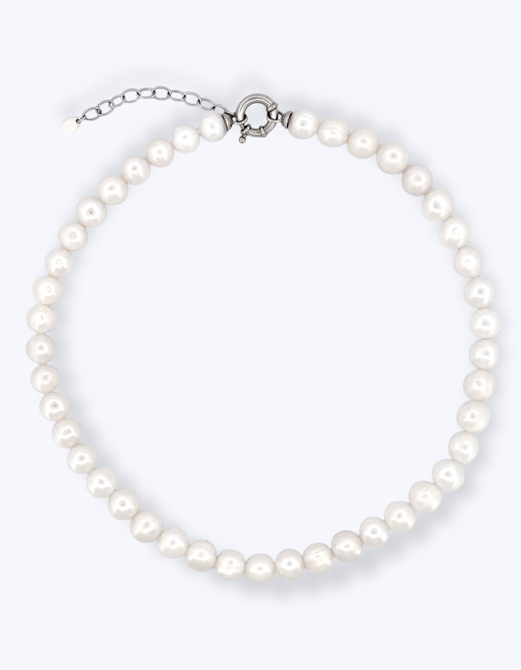 Girocollo di perle bianche coltivate disposte a cerchio con chiusura a molla circolare e catenella di estensione in argento 925 su sfondo bianco.